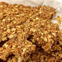 peanut butter and date granola broken into pieces on parchment paper