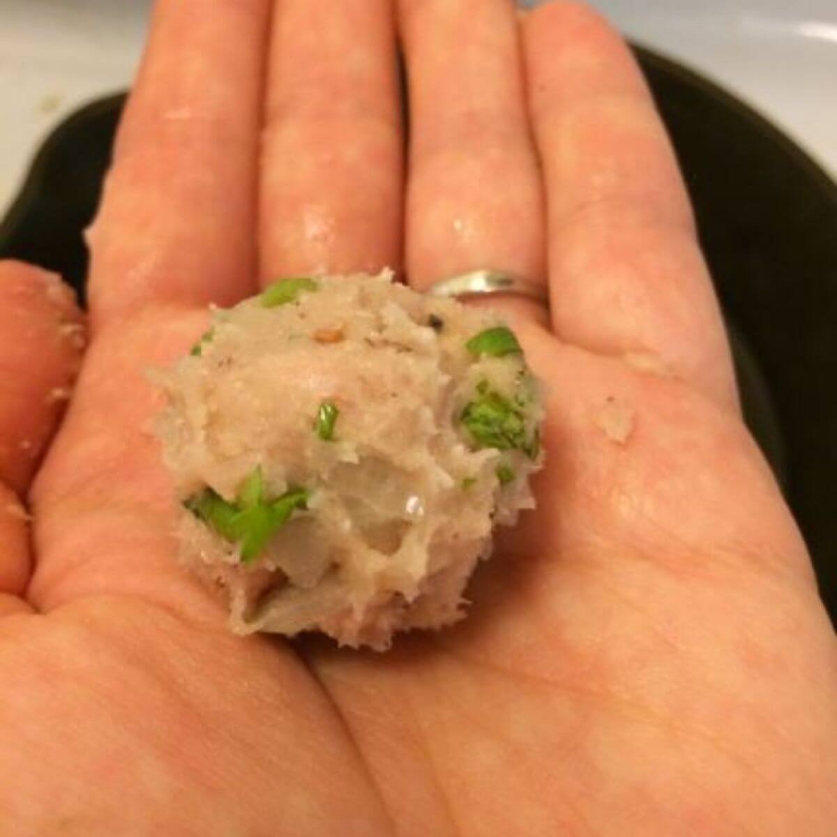 uncooked turkey meatball in palm of hand