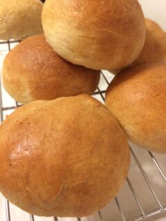 baked sweet rolls stacked on cooling rack