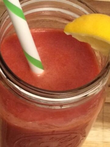 strawberry watermelon lemonade in mason jar with straw and lemon wedge
