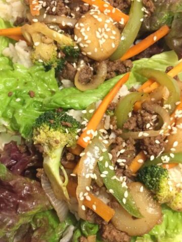 Asian style ground beef stir fry over red leaf lettuce