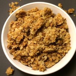 vanilla almond granola in white bowl with black background