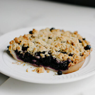 blueberry crisp pie on a white plate