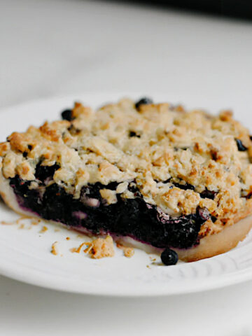 blueberry crisp pie on a white plate