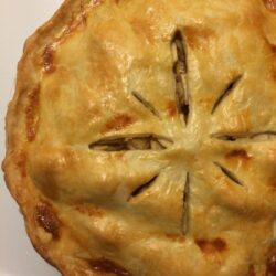 baked apple pie with fluted edges and star cuts on lid