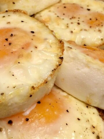 baked eggs with pepper flecks throughout stacked on wood board