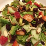 salad on green leaf lettuce with fresh avocado, strawberries, craisins, cucumber, almonds