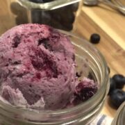 homemade blueberry ice cream in cup with blueberries on side