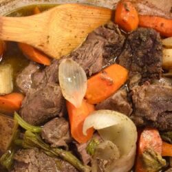 pot roast in corningware dutch oven with wooden spoon