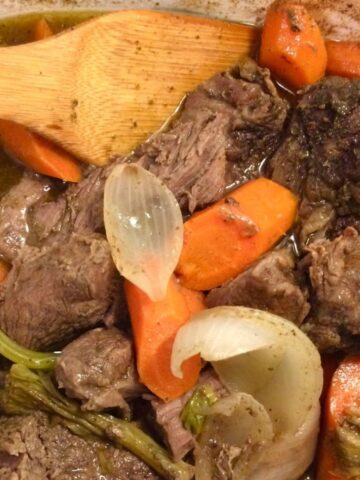 pot roast in corningware dutch oven with wooden spoon