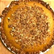 maple pumpkin pie on white plate on wood board