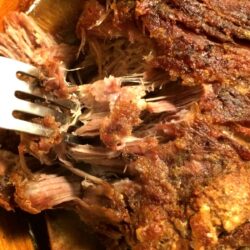 pork shoulder roast with crackling shredded with metal fork