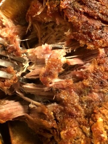 pork shoulder roast with crackling shredded with metal fork