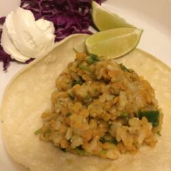 lentils and rice on soft corn tortillas with lime slices, purple cabbage, greek yogurt