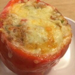 stuffed red bell pepper with melted cheese on top