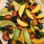 spinach salad with avocado, sweet potato, blueberries, cherry tomatoes, nectarine