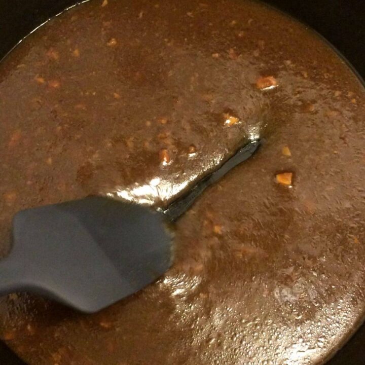 mongolian sauce in cast iron skillet thickened with silicone spatula drawing across the pan