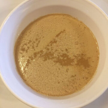 yeast soaking in water in white Corning Ware Bowl on white plate