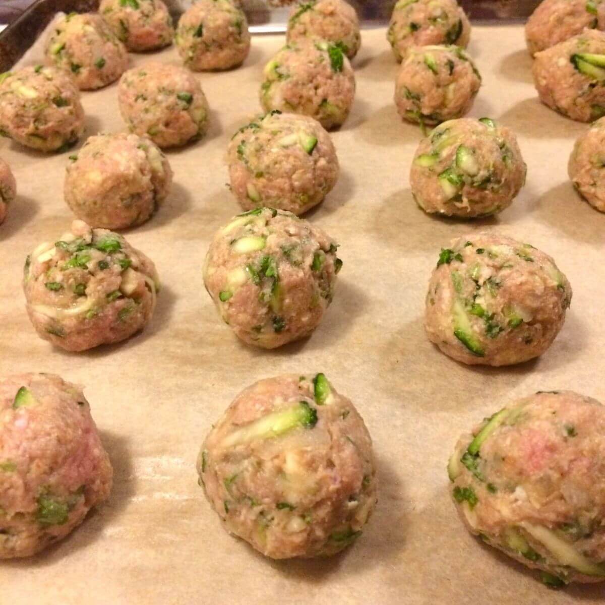 turkey meatballs formed and lined on baking sheet on parchment paper