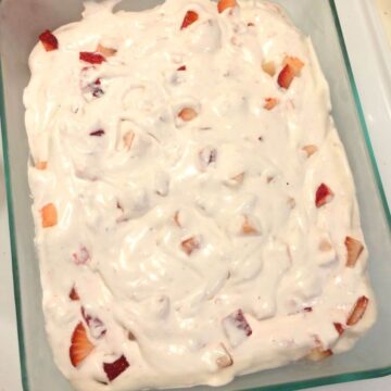 Whipped cream, coconut milk, cooked strawberries, and fresh diced strawberries all mixed in an 11 cup glass pyrex dish
