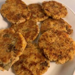 a pile of cooked fritters on a white oval plate