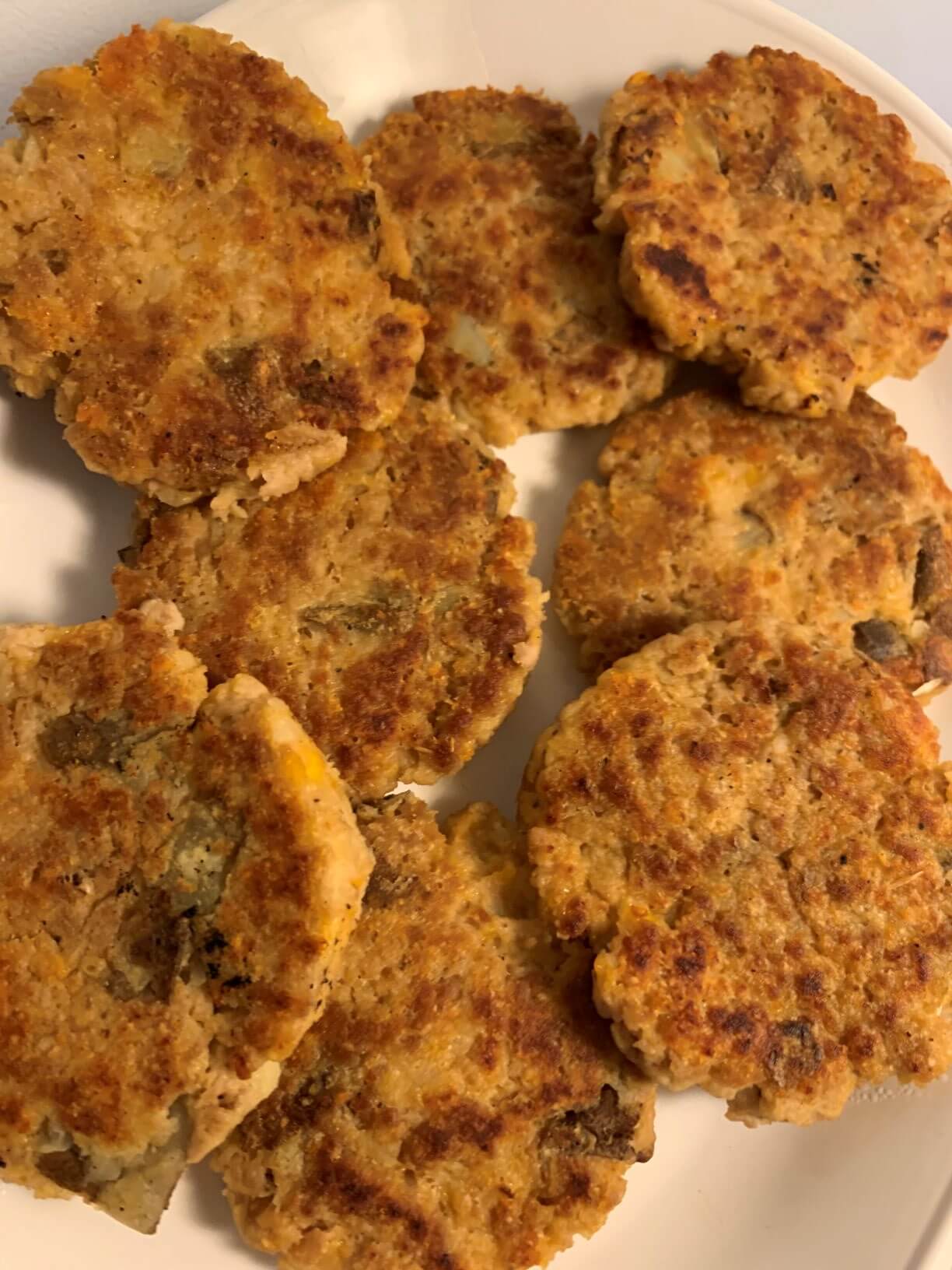 pile of cooked fritters on a white oval plate