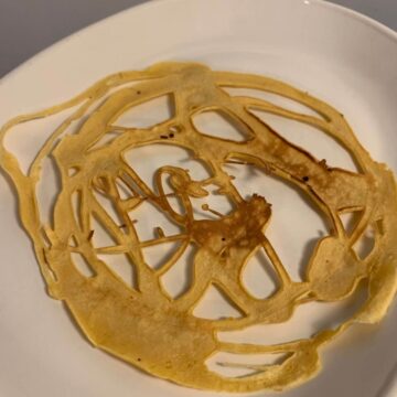 cooked lace pancake on white plate