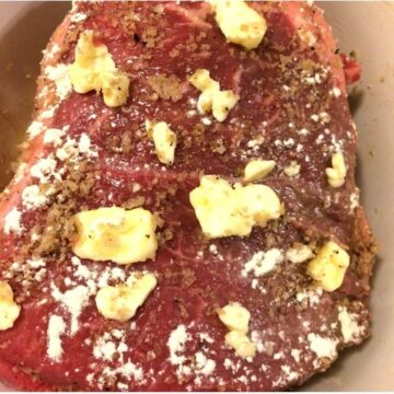 Beef Chuck with seasonings and butter in Corning Ware Dutch oven