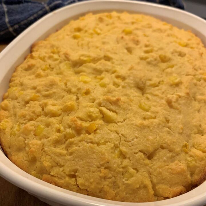 baked cornbread in a CorningWare casserole dish. Batter was chilled before baking for a chunkier finish. Blue and white towel in the background.