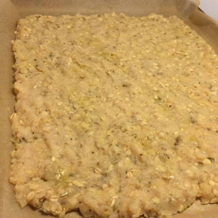 Ground meat pressed out on parchment paper the width of a cookie sheet.