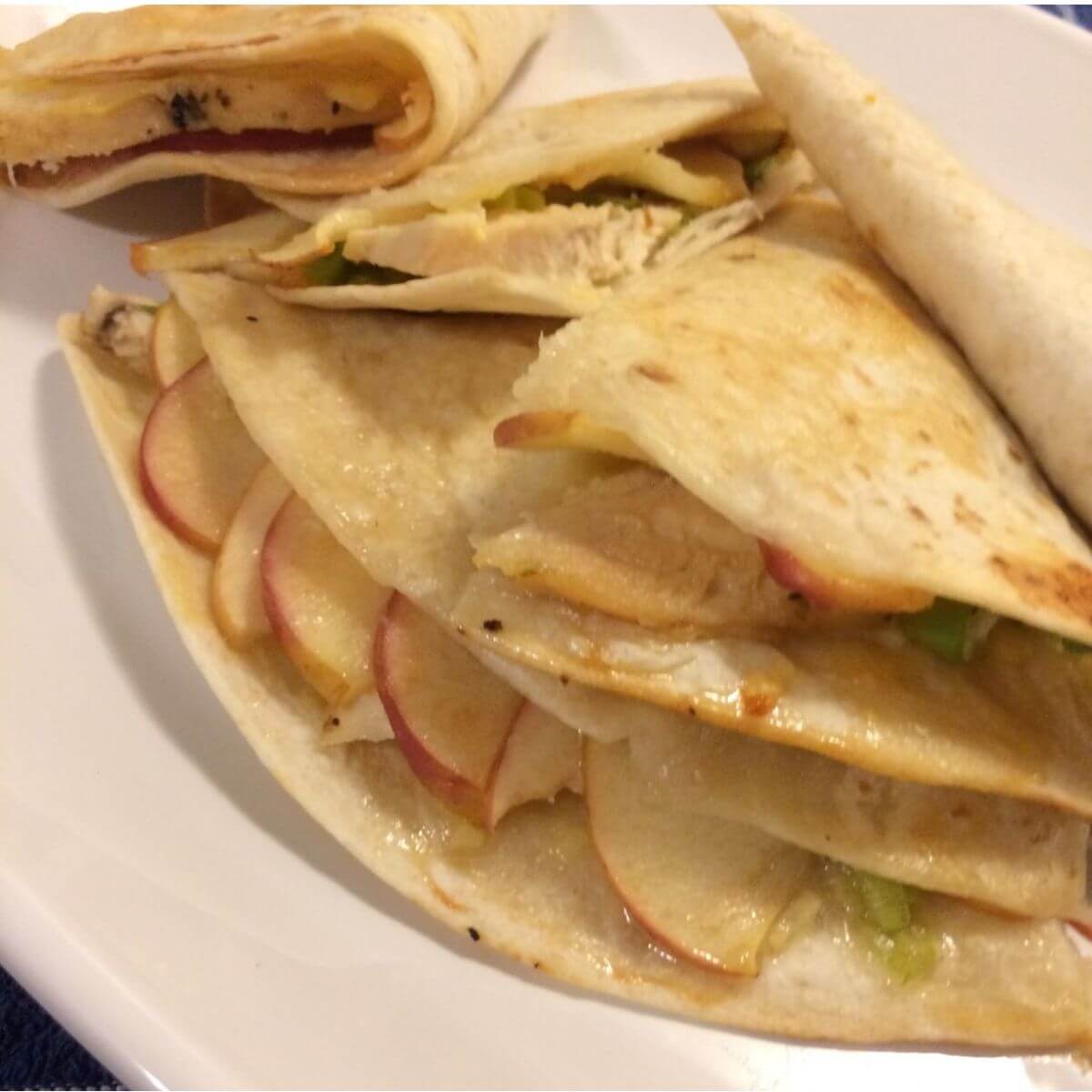 honey apple chicken quesadilla bake and sliced into triangles and stacked on a white plate