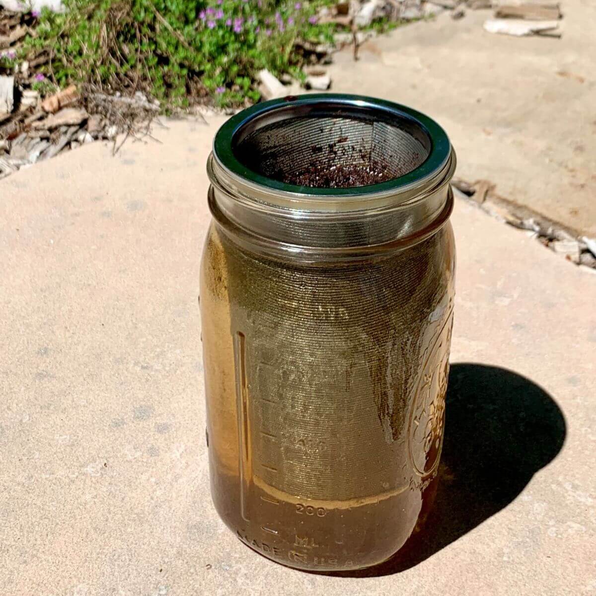 cold brew grounds mesh inset in mason jar, on flagstone.