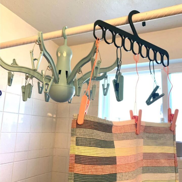 IKEA grip hanger with loop clips hanging off and octopus hanger on bathrub curtain rod.