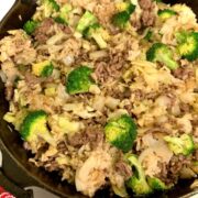 beef stir fry with rice, broccoli, cabbage, in cast iron skillet, close up square image.
